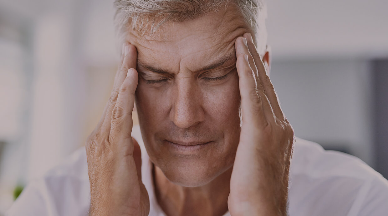 Middle-aged man showing signs of fatigue and stress, a common symptom of low testosterone levels.