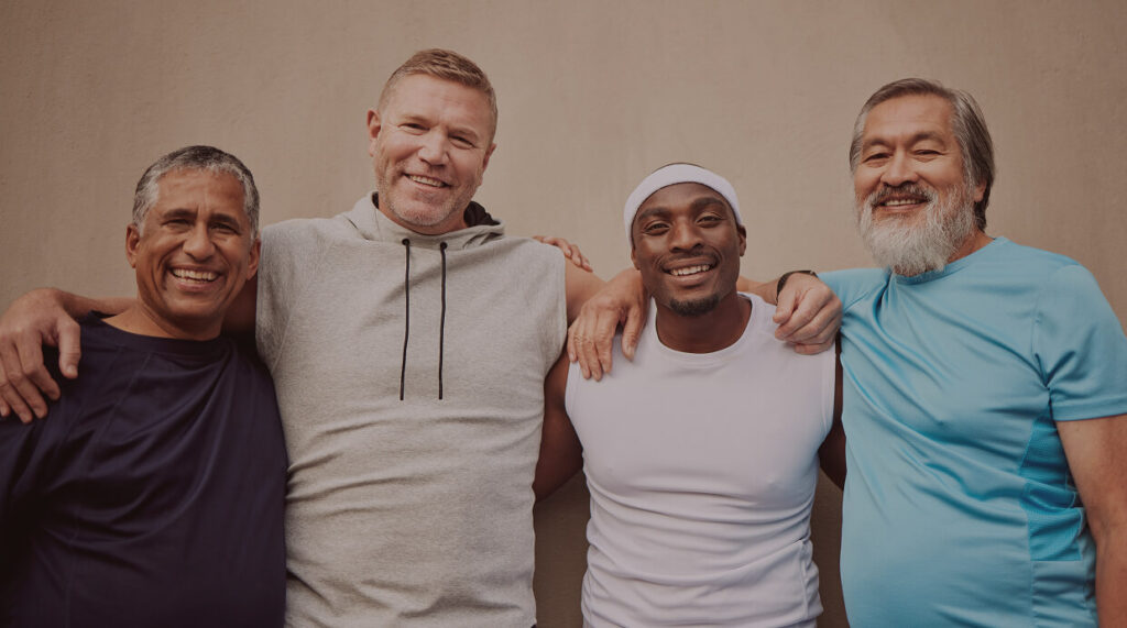 Group of middle-aged men smiling together, representing different age groups and the importance of monitoring testosterone levels for optimal health