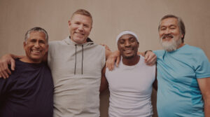 Group of middle-aged men smiling together, representing different age groups and the importance of monitoring testosterone levels for optimal health