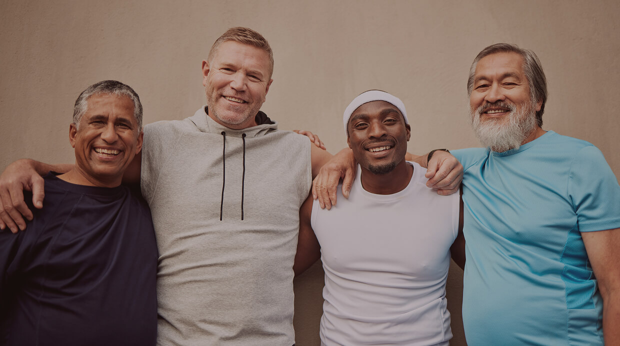 Group of middle-aged men smiling together, representing different age groups and the importance of monitoring testosterone levels for optimal health